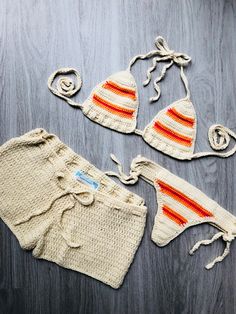 two crocheted swimsuits with matching hats and drawstring on a wooden surface