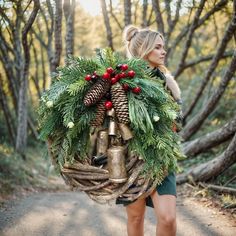 a woman carrying a wreath and bells on her back