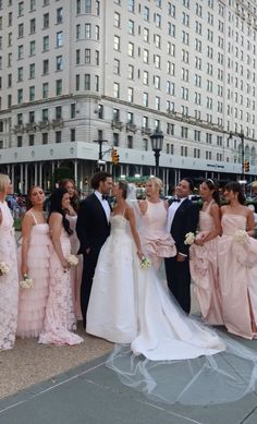 a group of people standing next to each other in front of a large white building