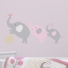 a baby's room with an elephant wall decal and crib bedding