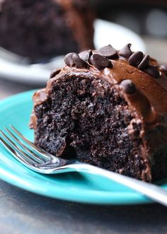 a piece of chocolate cake on a blue plate with a fork in front of it