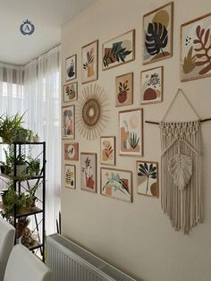 a living room with pictures on the wall and plants in potted planters next to it