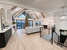 a living room filled with furniture and a christmas tree in the middle of the room