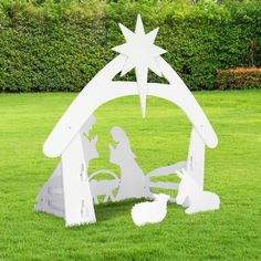 a white nativity scene in the grass