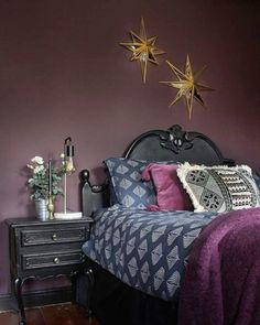 a bed room with a neatly made bed and two star decorations on the headboard