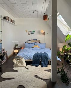 a bed sitting under a window next to a white rug on top of a wooden floor