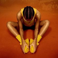 a woman sitting on the ground with her hands in her pockets and wearing yellow socks