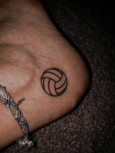 a tattoo on the foot of a person with a volleyball ball in the middle of it