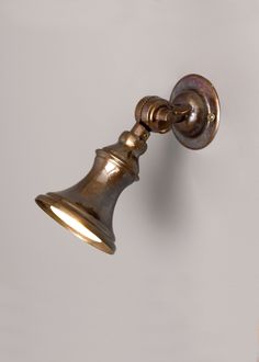 an antique brass wall light with a white background