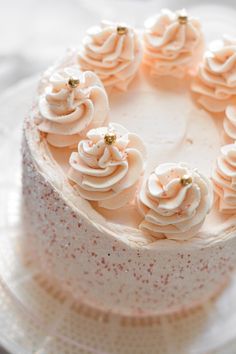 a white cake with frosting and sprinkles arranged in the shape of a circle