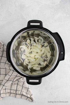 onions are being cooked in an instant pot on the stove top next to a cloth