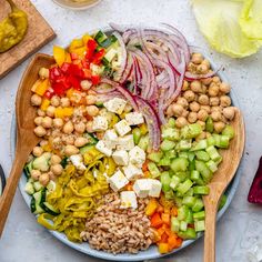 a plate filled with vegetables and chickpeas on top of a table next to other ingredients