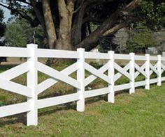 a white picket fence in front of a tree