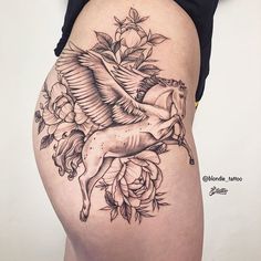 a woman's thigh with a tattoo of a horse and roses on it,