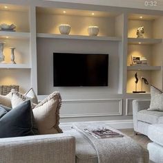 a living room filled with furniture and a flat screen tv mounted on the wall above it