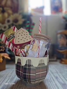 a basket filled with candy and cookies sitting on top of a table next to a christmas tree