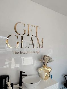 a white counter top sitting under a sign that says get glam