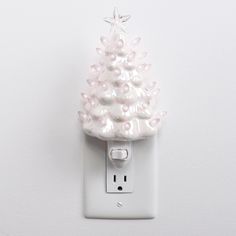 a white light switch cover with a christmas tree decoration on the side and an outlet