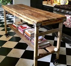 a wooden table sitting on top of a black and white checkered floor next to an oven