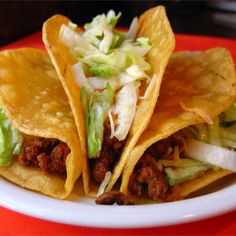 three tacos with meat and lettuce on a plate