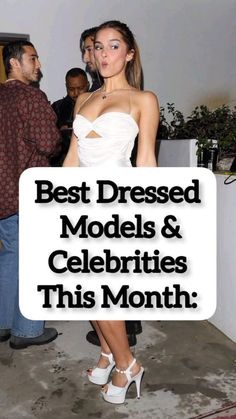 a woman in white dress standing next to a man with a sign that says best dressed models and celebrities this month