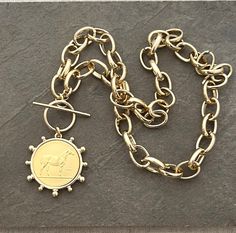 Please read before ordering. This item is no longer available for pre-Christmas delivery. This item will arrive after Christmas. Thank you! A stunning replica French Horse gold coin pendant in a gold bezel setting dangles from a  gold rolo chain with a toggle clasp at the front or lobster clasp at the back. The coin is reversible to be worn with either side showing.  Details:  Pendant measures  1.5" in diameter. Gold chain links are 11x16 mm. Gold  lobster or toggle clasp positioned in front (sh Gold Medallion Jewelry With Toggle Clasp, Gold Toggle Necklace With Coin Pendant, Vintage Gold Round Toggle Necklace, Gold Medallion Necklace With Lobster Clasp, Gold-tone Medallion Coin Necklace, Gold-tone Coin Necklace With Adjustable Chain, Elegant Coin-shaped Medallion Necklace With Adjustable Chain, Brass Coin-shaped Adjustable Chain Necklace, Chunky Gold Necklace