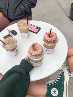 people sitting at a table with donuts and drinks