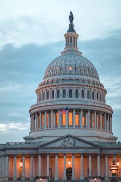 the capitol building is lit up at night with lights on it's dome and pillars