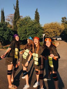 three girls in costumes are posing for the camera with their skateboards and helmets on