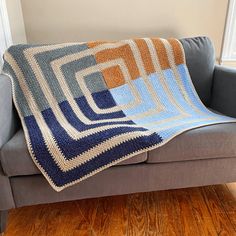 a couch with a crocheted blanket sitting on top of it