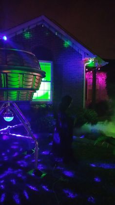 a man standing in front of a house covered in purple and green lights