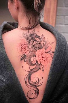 a woman's back tattoo with flowers and a snake