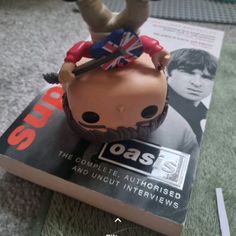 a close up of a toy on top of a book with an upside down head