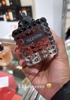 a person holding a bottle of perfume in their hand with the words valentine on it