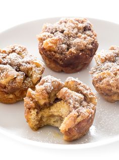 several pastries on a white plate with powdered sugar