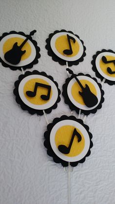 the cupcakes are decorated with black and yellow icing, music notes on them