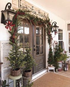 the front door of a house decorated for christmas with evergreens and pine cones on it