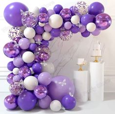 the balloon arch is decorated with purple and white balloons