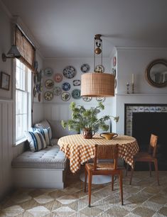 a dining room table with plates on the wall and a bench in front of it