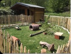 there is a small wooden cabin in the yard with benches and logs on the grass