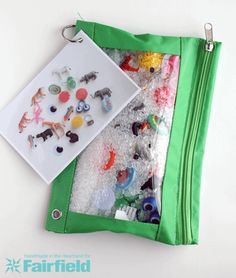 a green zippered bag filled with lots of toys and magnets on top of it