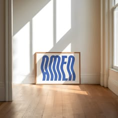 a blue sign sitting on top of a hard wood floor next to a white wall