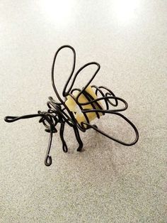 a wire sculpture sitting on top of a white floor