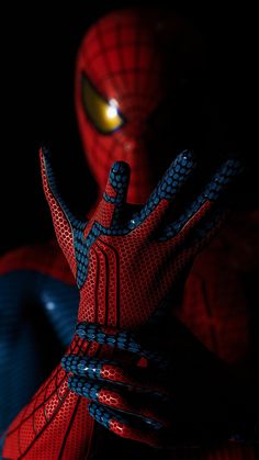 a close up of a spider man with his hands in front of him and glowing eyes