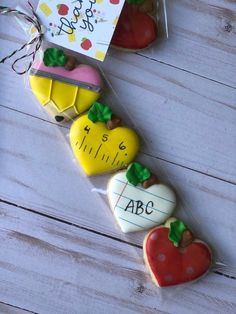 decorated cookies in cellophane wrapped in plastic on white wood background with happy birthday card