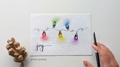 a hand holding a pen and drawing on a piece of paper with the word joy written in it