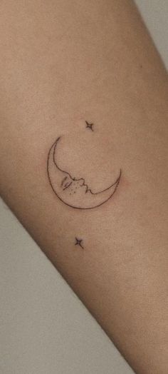 a small crescent and star tattoo on the arm