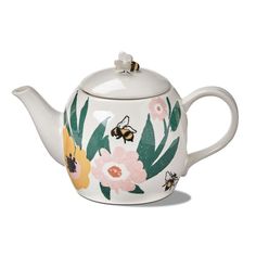 a teapot with flowers and bees painted on it