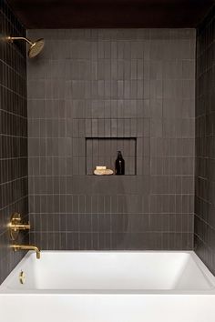 a white bath tub sitting inside of a bathroom next to a shower faucet