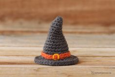 a crocheted witch hat sitting on top of a wooden table